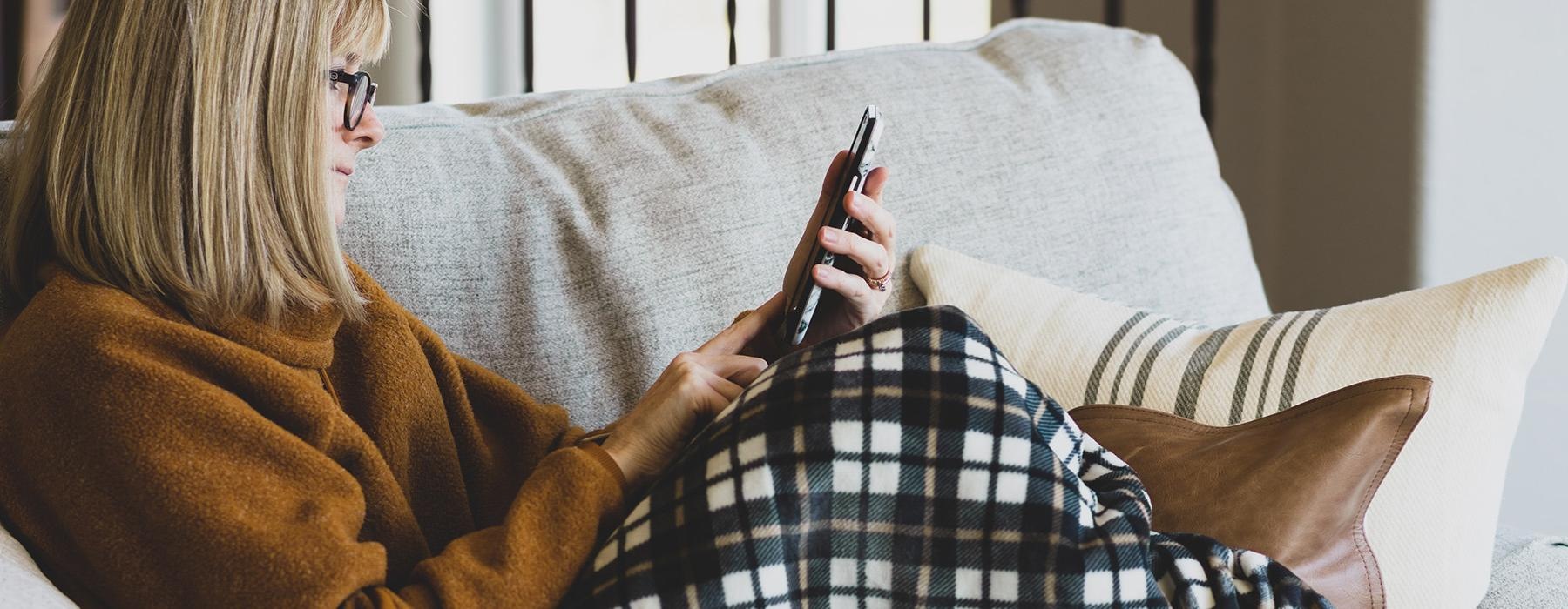 a man sitting on a couch and holding a phone