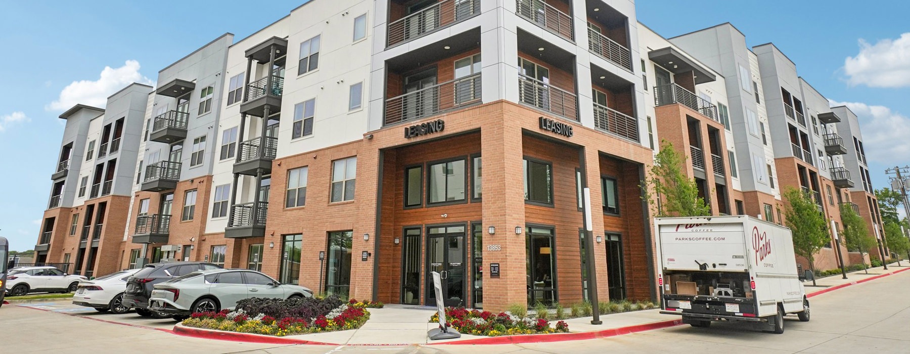 building with many windows with vehicles parked in front